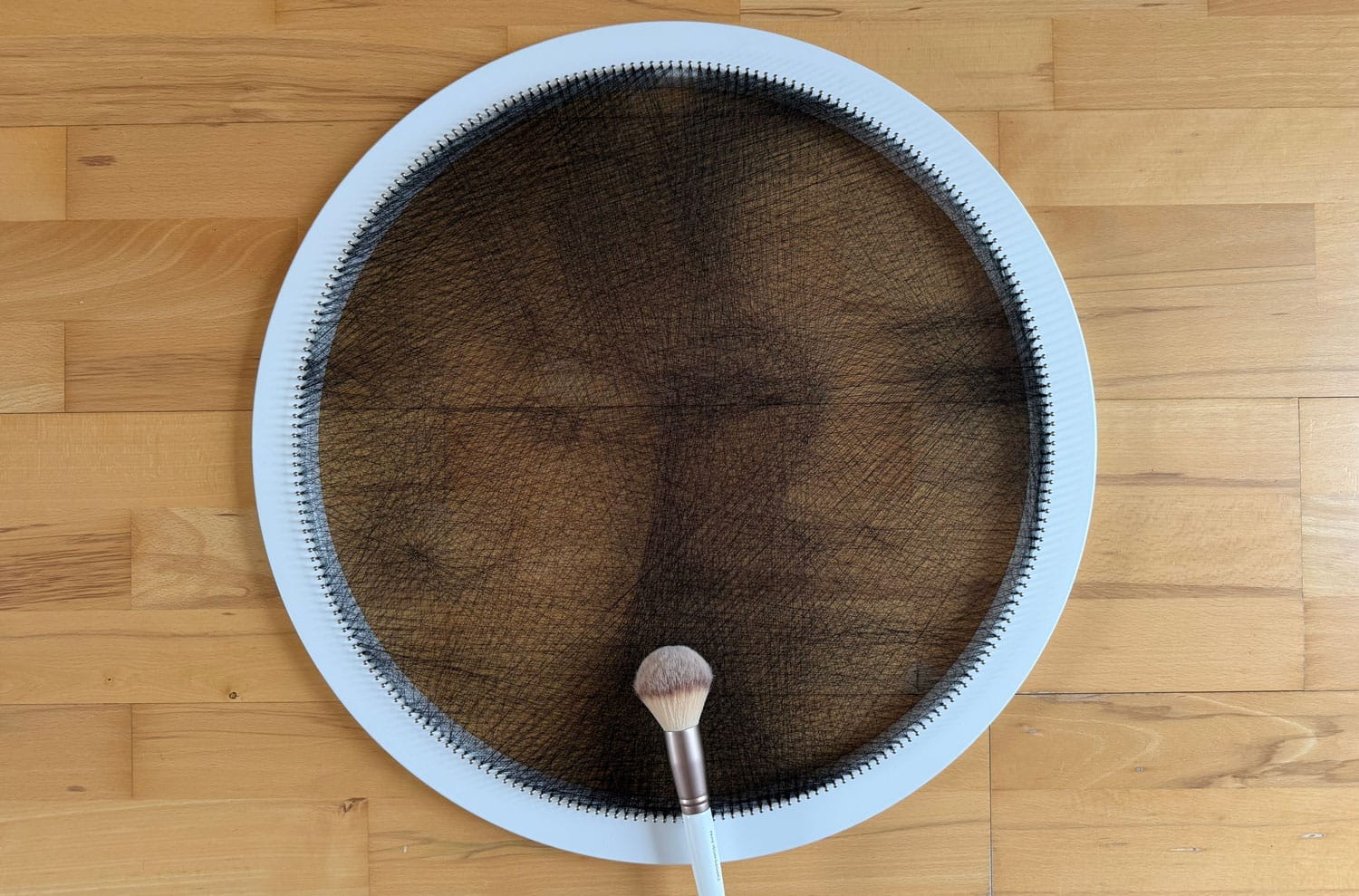 Modelo Ring de string art con una brocha de maquillaje suave